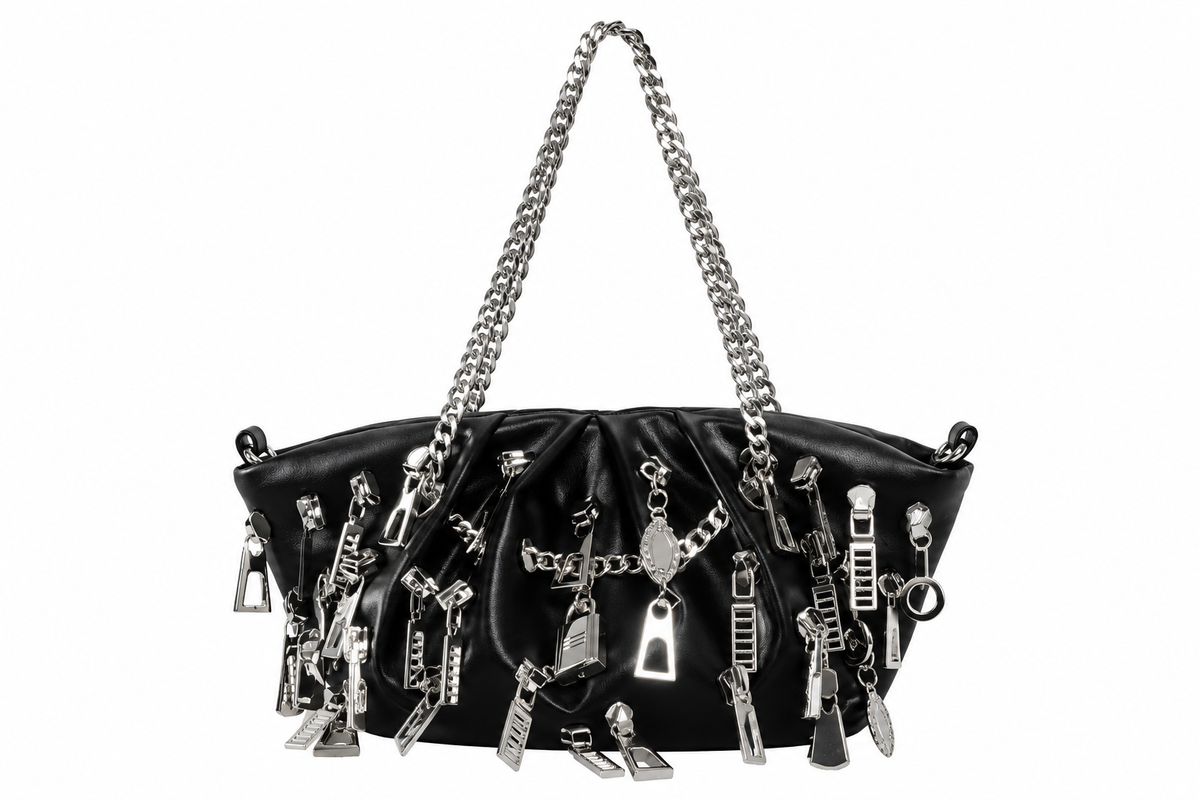 A black leather shoulder bag adorned with numerous silver zipper pulls, charms, and chain details, featuring a silver chain strap, set against a plain white background.